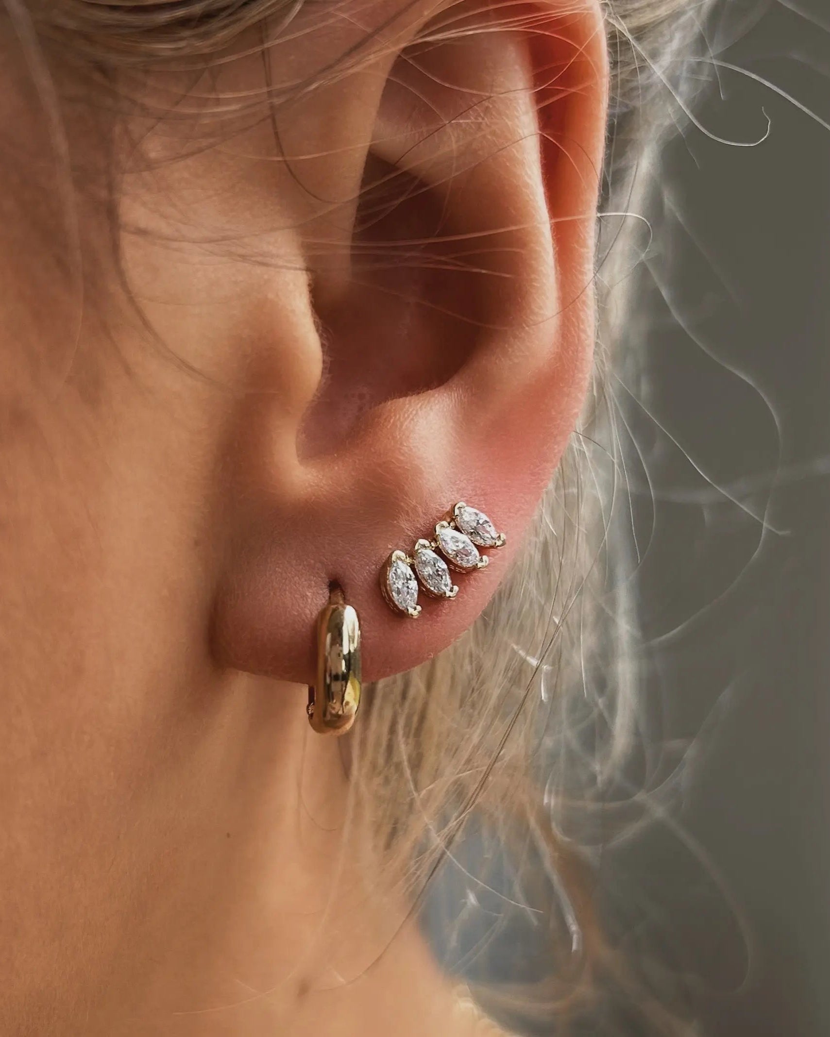 Close-up of ear wearing Cluster Curved Stud Earrings in 18k gold-filled
