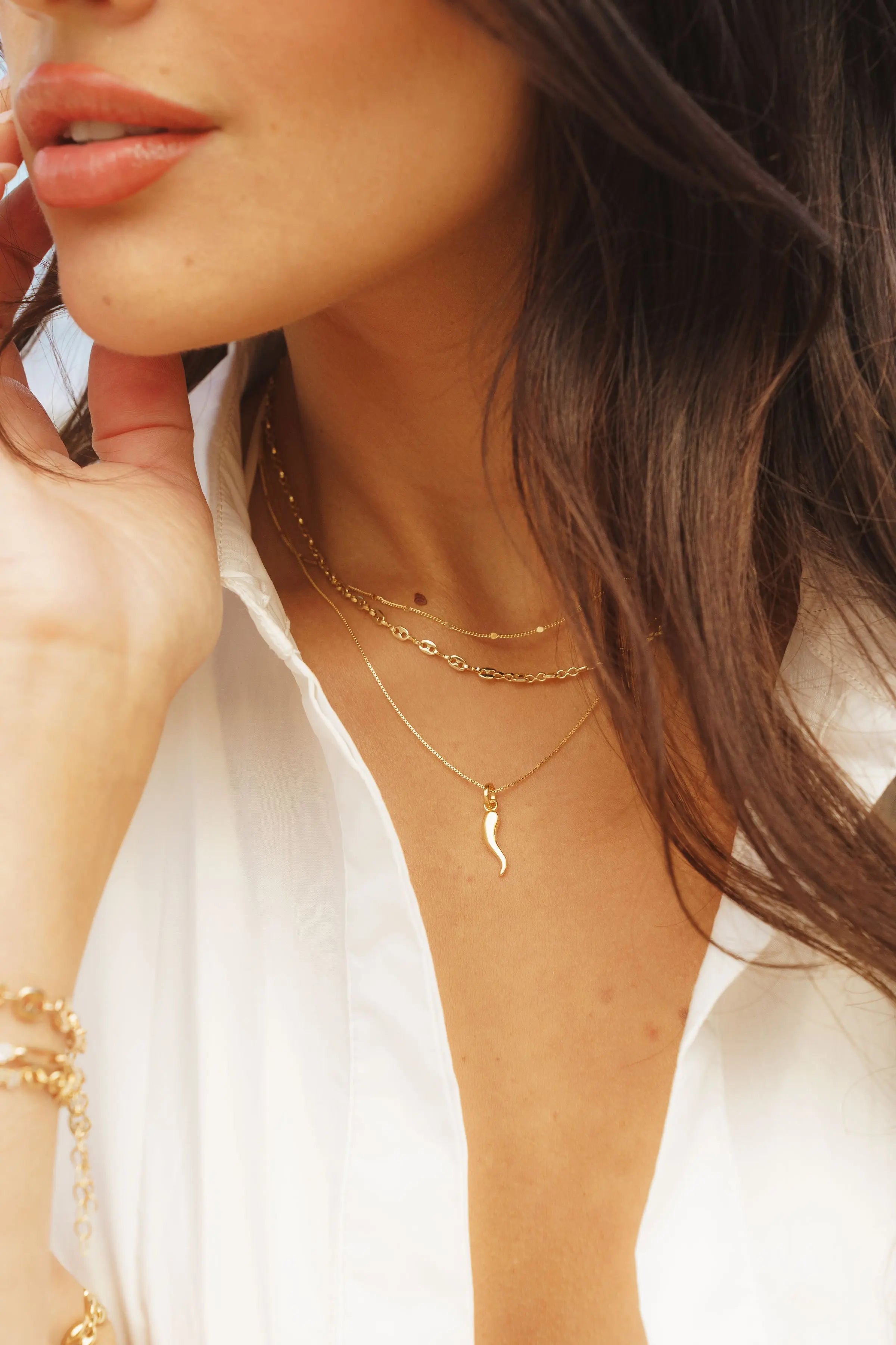 Cornicello Horn Pendant styled in a layered gold chain look on model