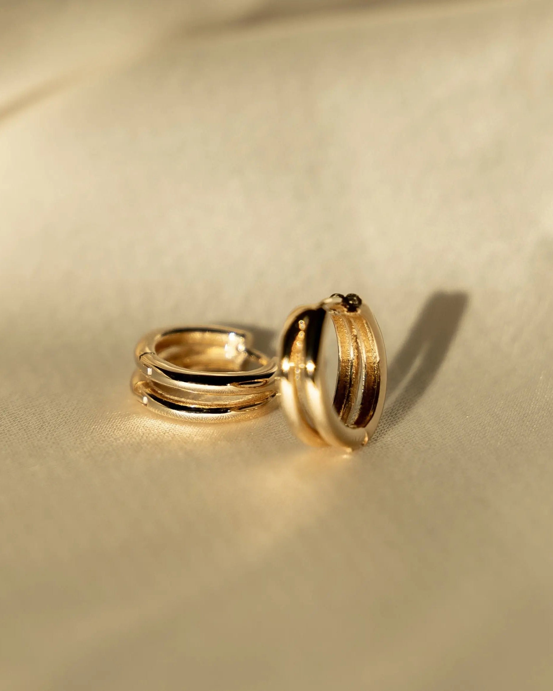 Double Huggie Hoops in 18k gold-filled displayed on satin fabric for IGGI Jewellery