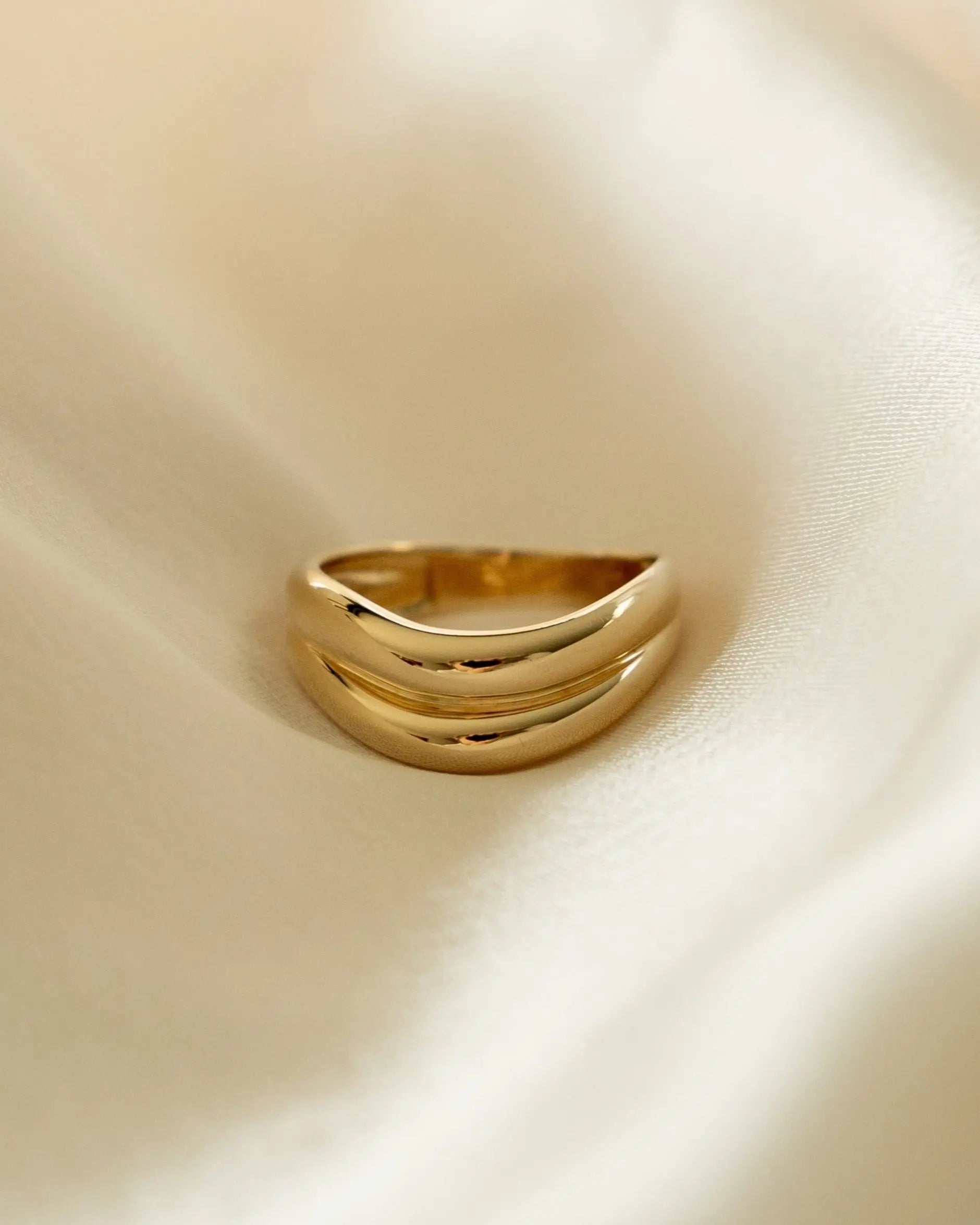 Close-up of Halona Ring on fabric, showcasing gold-filled dome band design