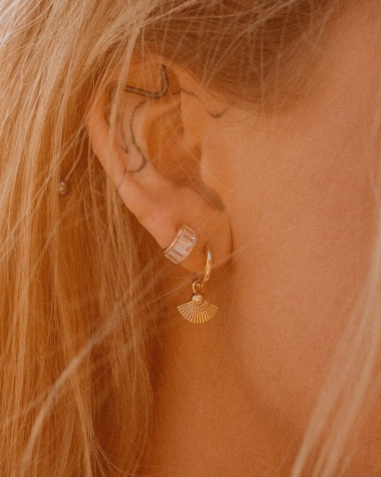 Model in sunlight wearing Heka Hoops 18k gold-filled earrings by IGGI Jewellery