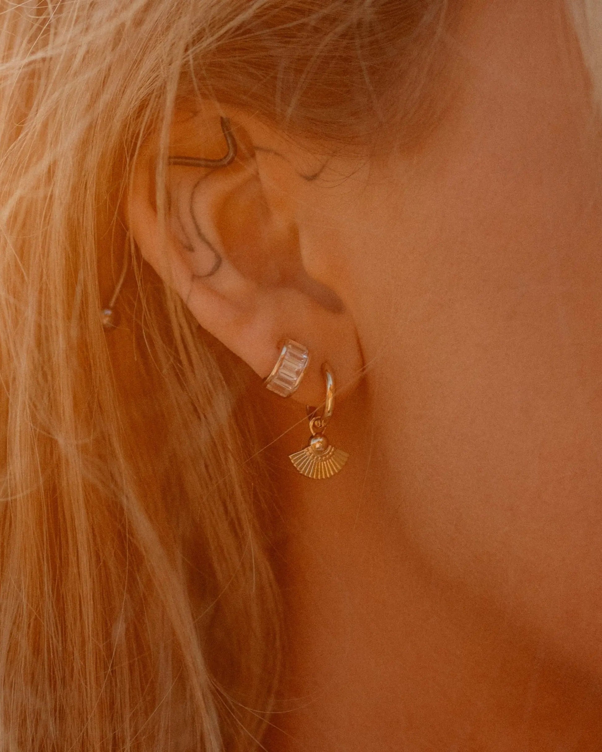 Model wearing Heka Hoops 18k gold-filled earrings with fan-shaped charm