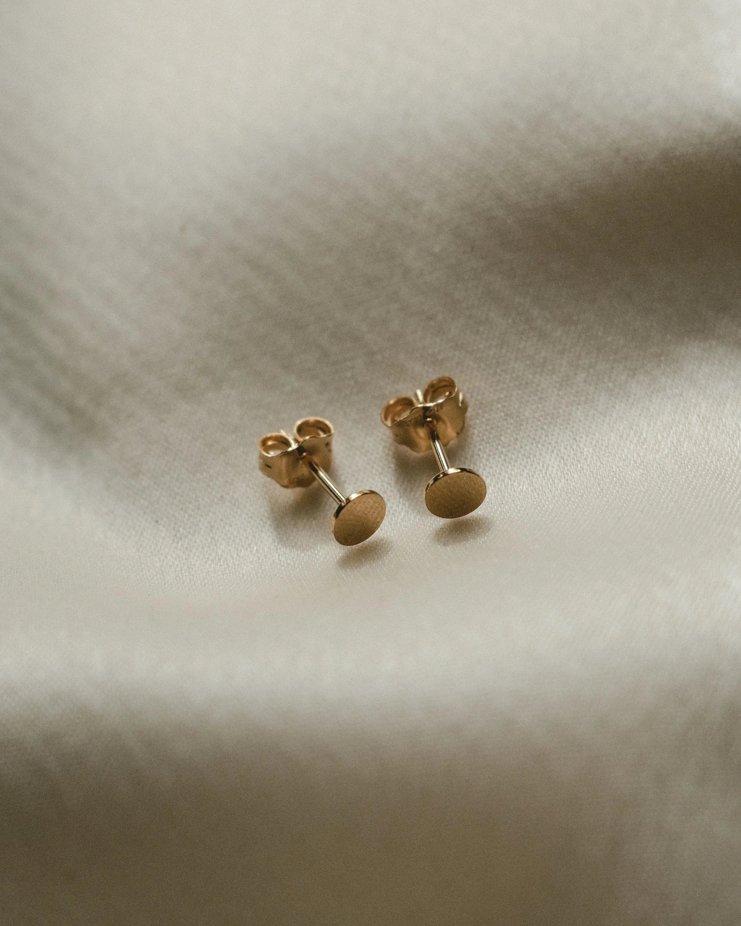 Round Disc Studs displayed on soft fabric for IGGI Jewellery product detail