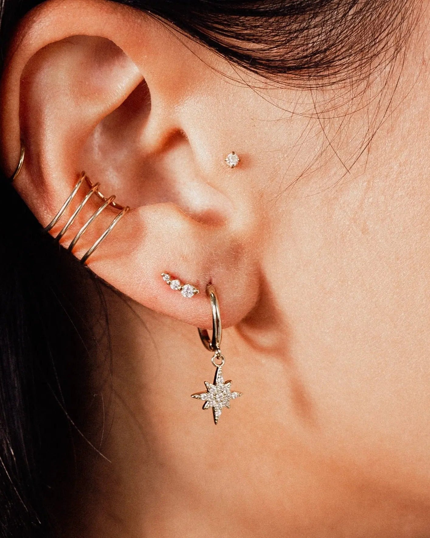 Close-up of IGGI Star Drop Earrings in 18k gold-filled with cubic zirconia charm styled on ear
