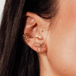 Model wearing IGGI Jewellery Bow Stud Earrings in 18k gold-filled finish – delicate bow design styled with multiple ear piercings.