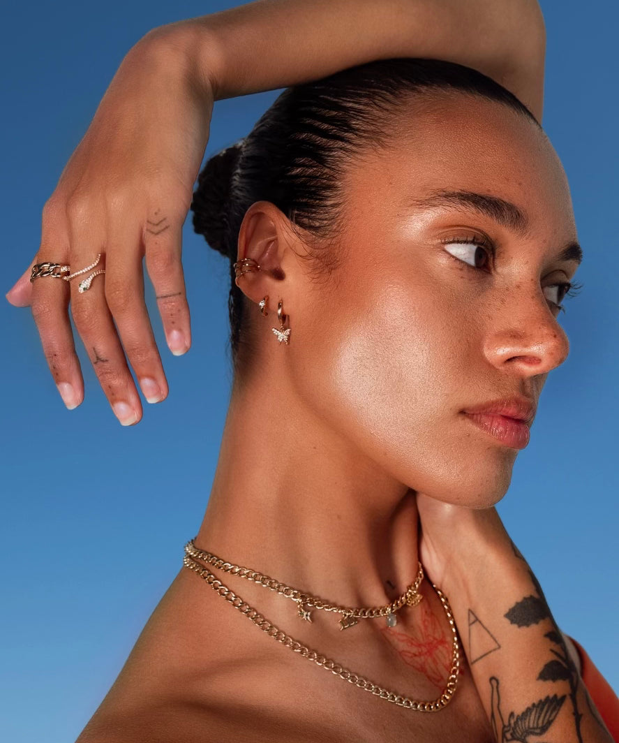 Model wearing Butterfly Drop Huggies by IGGI Jewellery – 18k gold-filled butterfly earrings styled with layered gold chains.