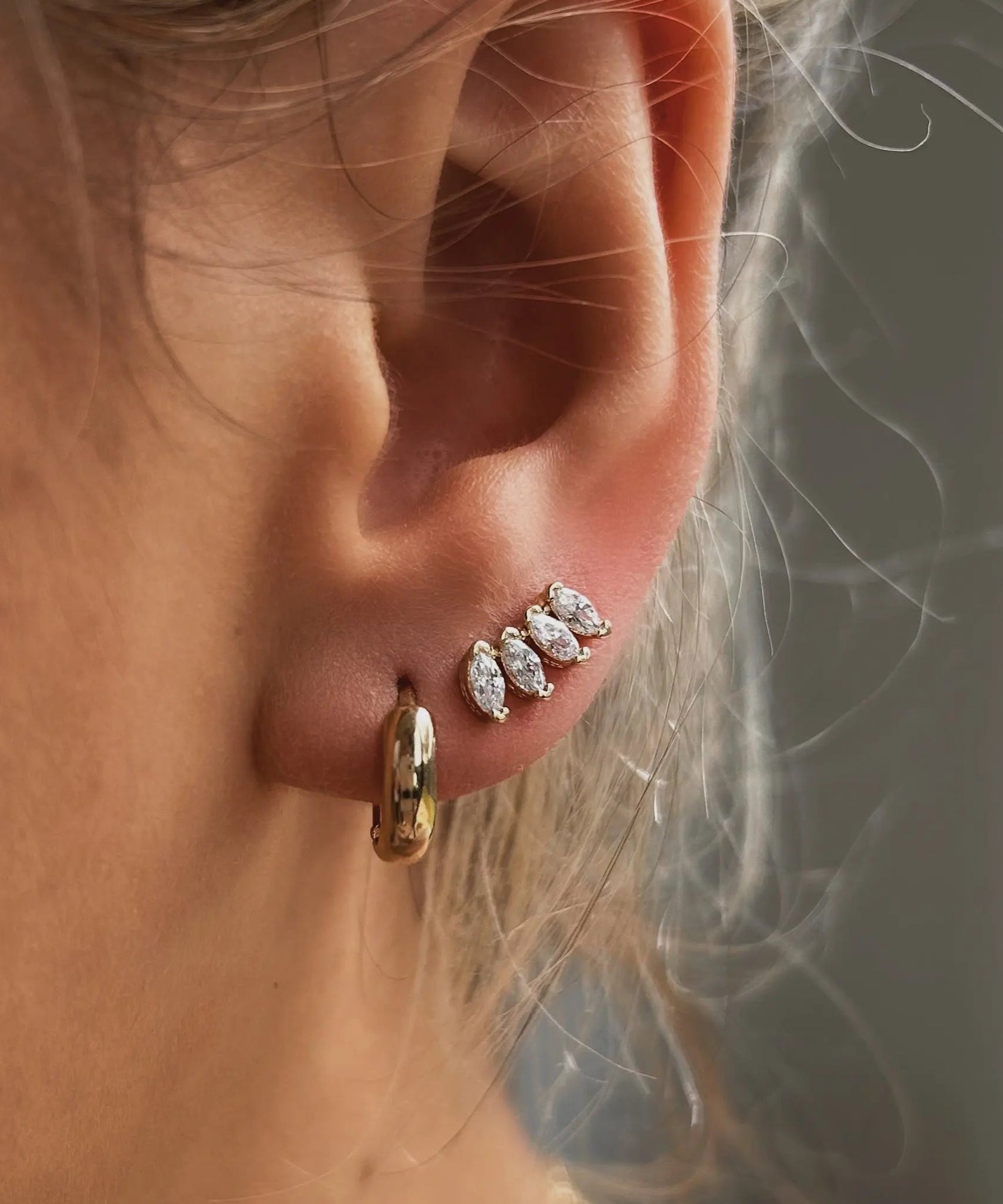 Close-up of ear wearing Cluster Curved Stud Earrings in 18k gold-filled