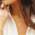 Cornicello Horn Pendant styled in a layered gold chain look on model