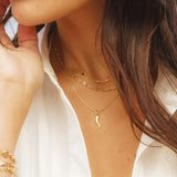 Cornicello Horn Pendant styled in a layered gold chain look on model