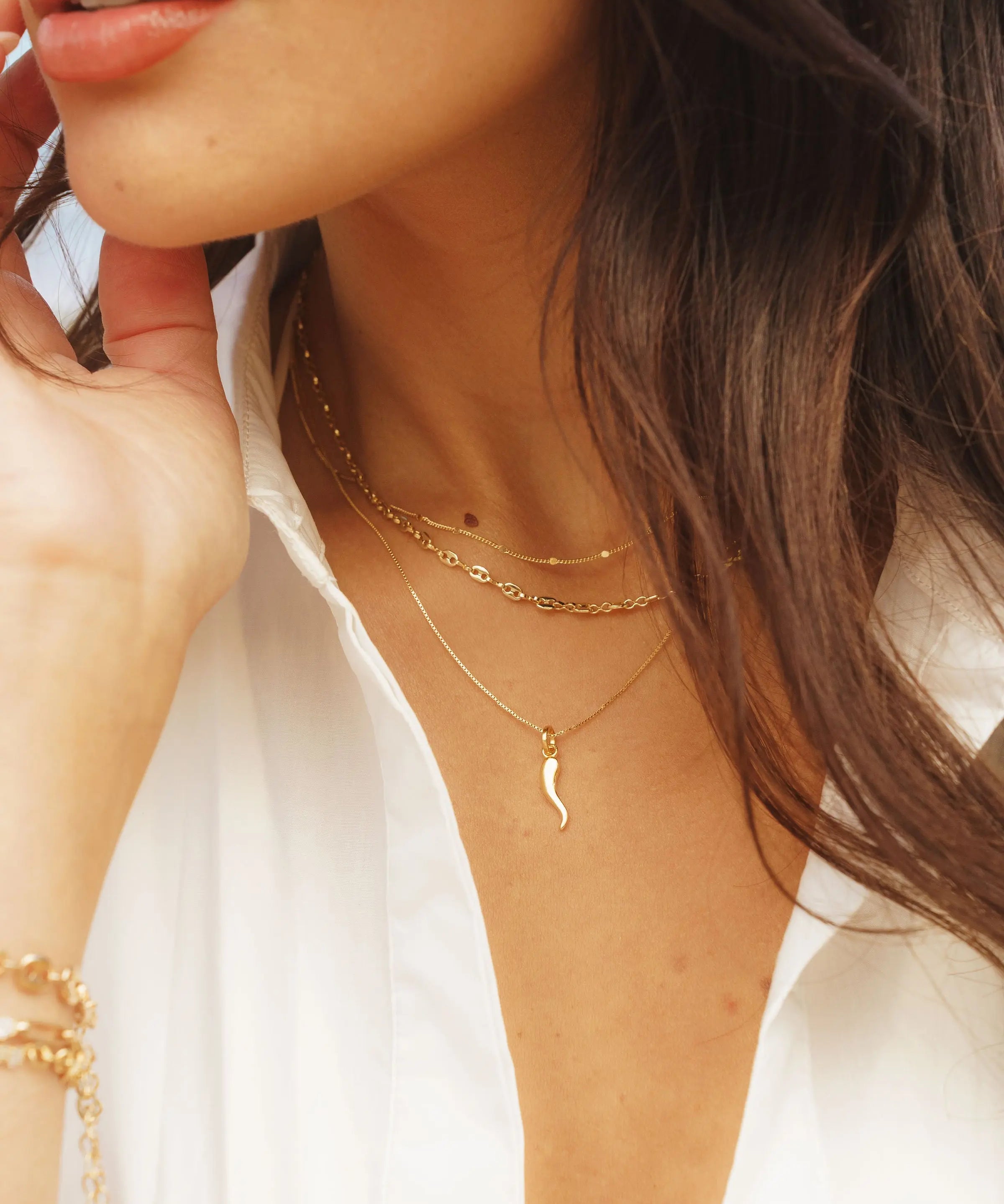 Cornicello Horn Pendant styled in a layered gold chain look on model