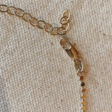 Close-up of Dotted Chain Necklace in 18k gold-filled showing clasp and extender detail on linen backdrop