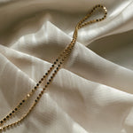 Side angle of model wearing the Dotted Chain Necklace layered with other IGGI Jewellery pieces