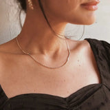 Close-up of Dotted Chain Necklace layered with other IGGI gold necklaces on model’s neck