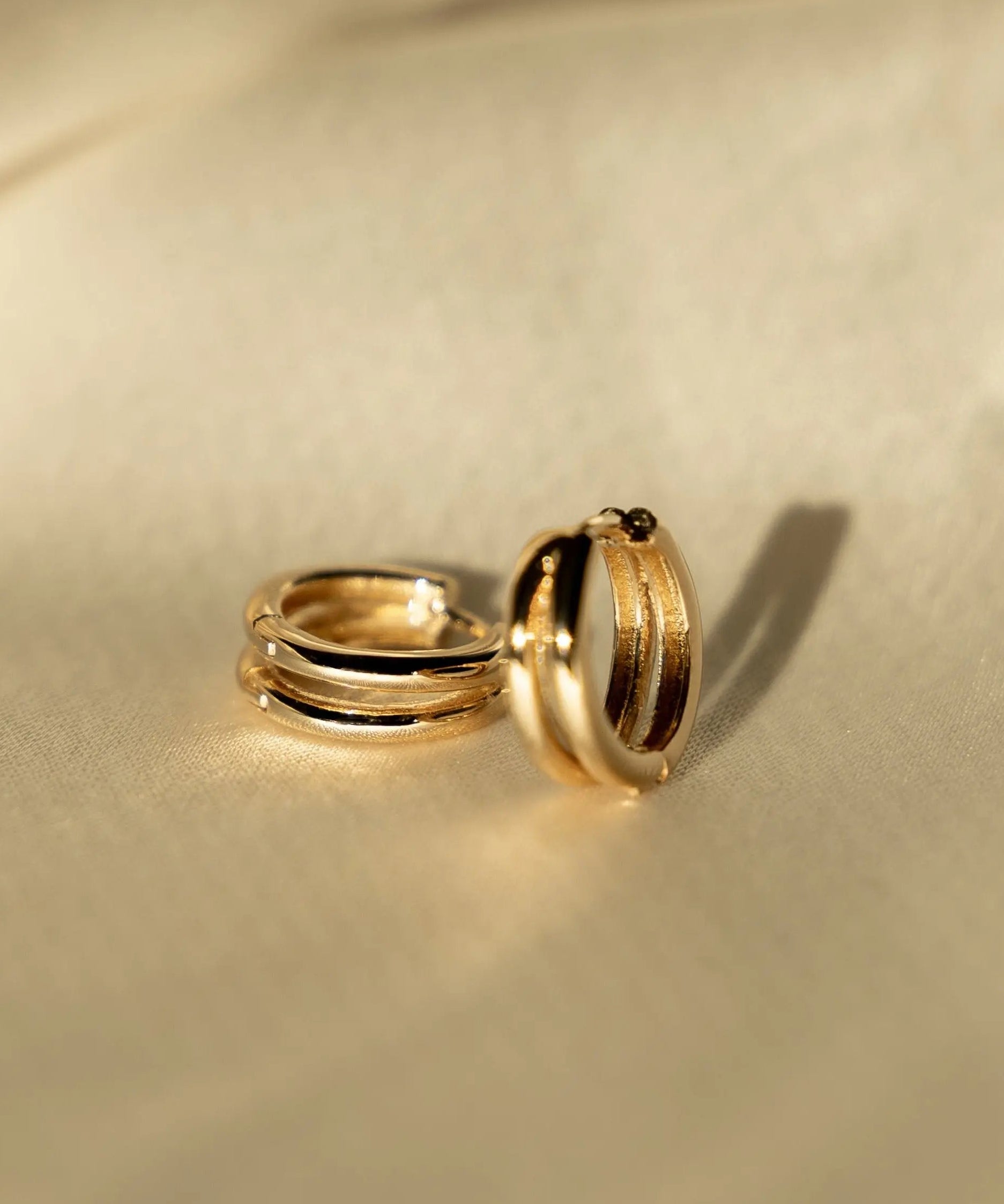 Double Huggie Hoops in 18k gold-filled displayed on satin fabric for IGGI Jewellery