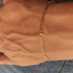 Close-up of IGGI Jewellery Flat Figaro Chain Bracelet in 18k gold-filled finish, shown on wrist.