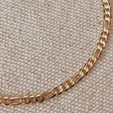 Gold chain on a beige textured fabric background