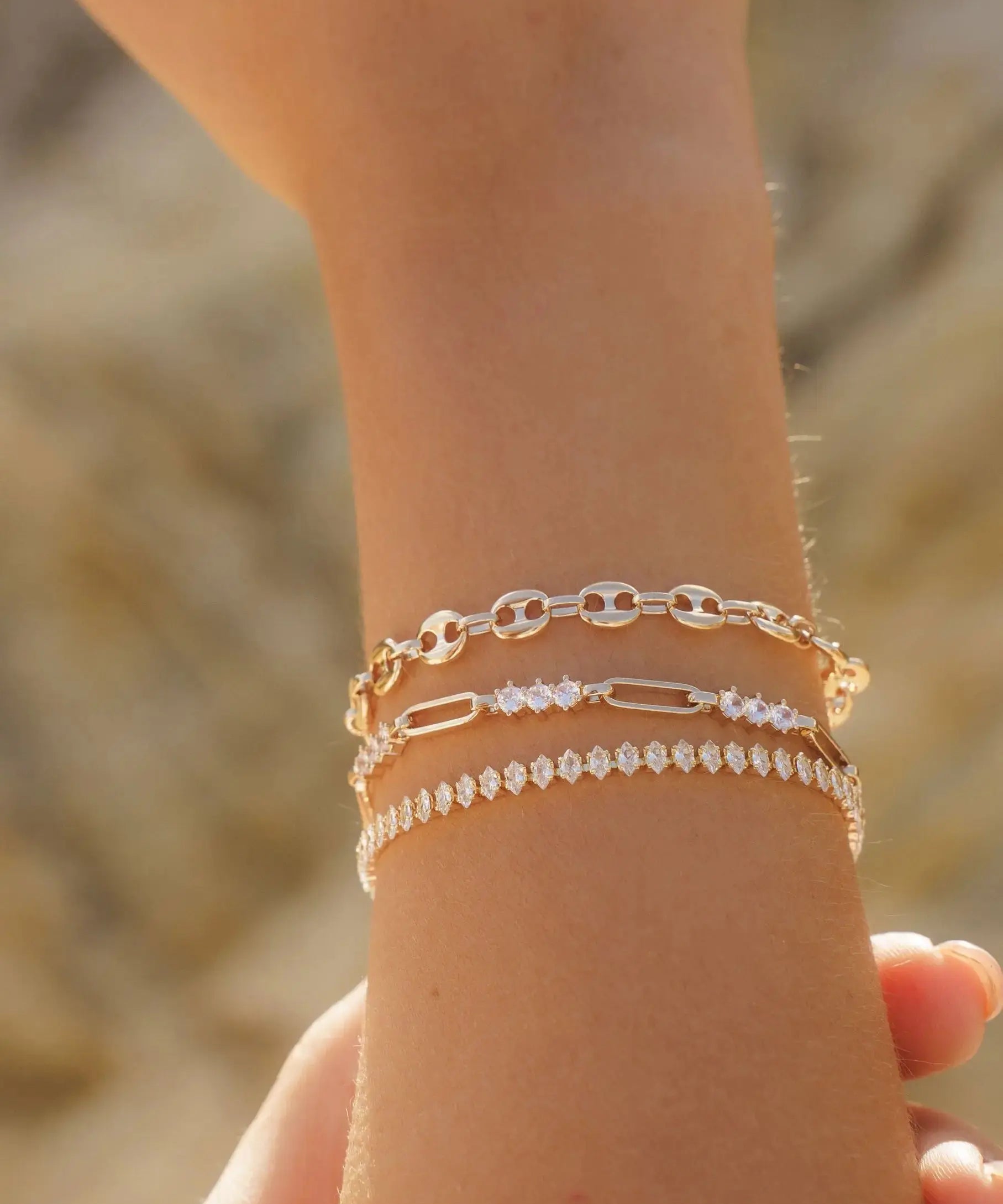 Francesca Bracelet styled with layered gold chain bracelets on wrist, featuring crystal accents by IGGI Jewellery.