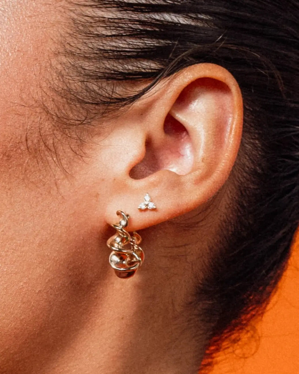 Model wearing Gold Tri CZ Stud Earrings with cubic zirconia stones by IGGI Jewellery