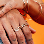 Close-up of hands wearing the Harlow Ring stacked with other gold rings and bangles by IGGI Jewellery