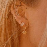 Model in sunlight wearing Heka Hoops 18k gold-filled earrings by IGGI Jewellery