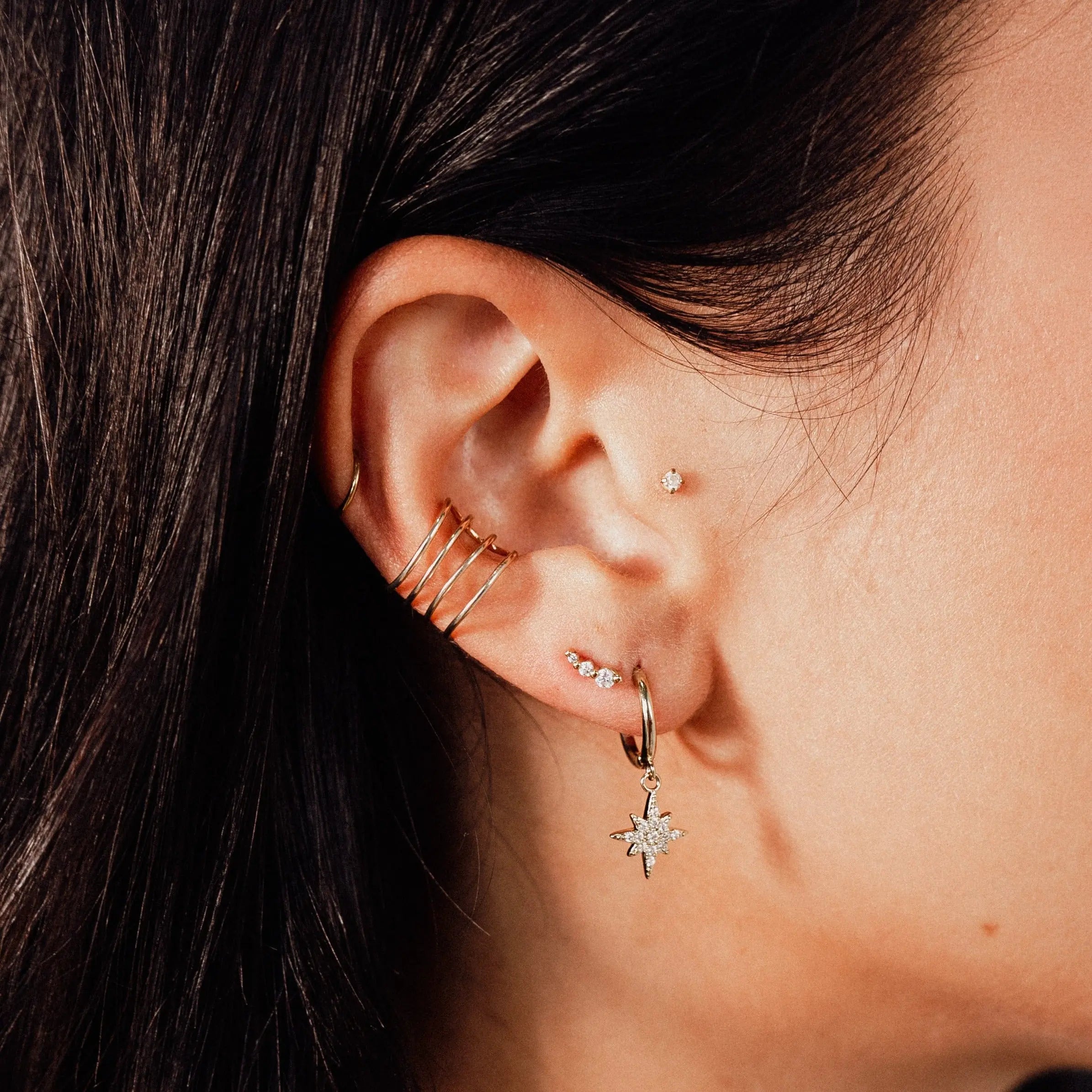 Lola Mini Studs styled in an ear piercing stack with gold hoops and star drop earrings by IGGI Jewellery.