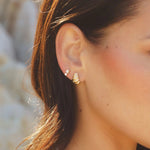 Model wearing Moxie Twisted C-Hoop earrings in 18k gold-filled by IGGI Jewellery