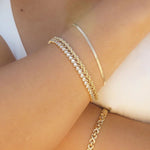 Rope Chain Bracelet stacked with gold chain bracelets on wrist for an elegant layered look.