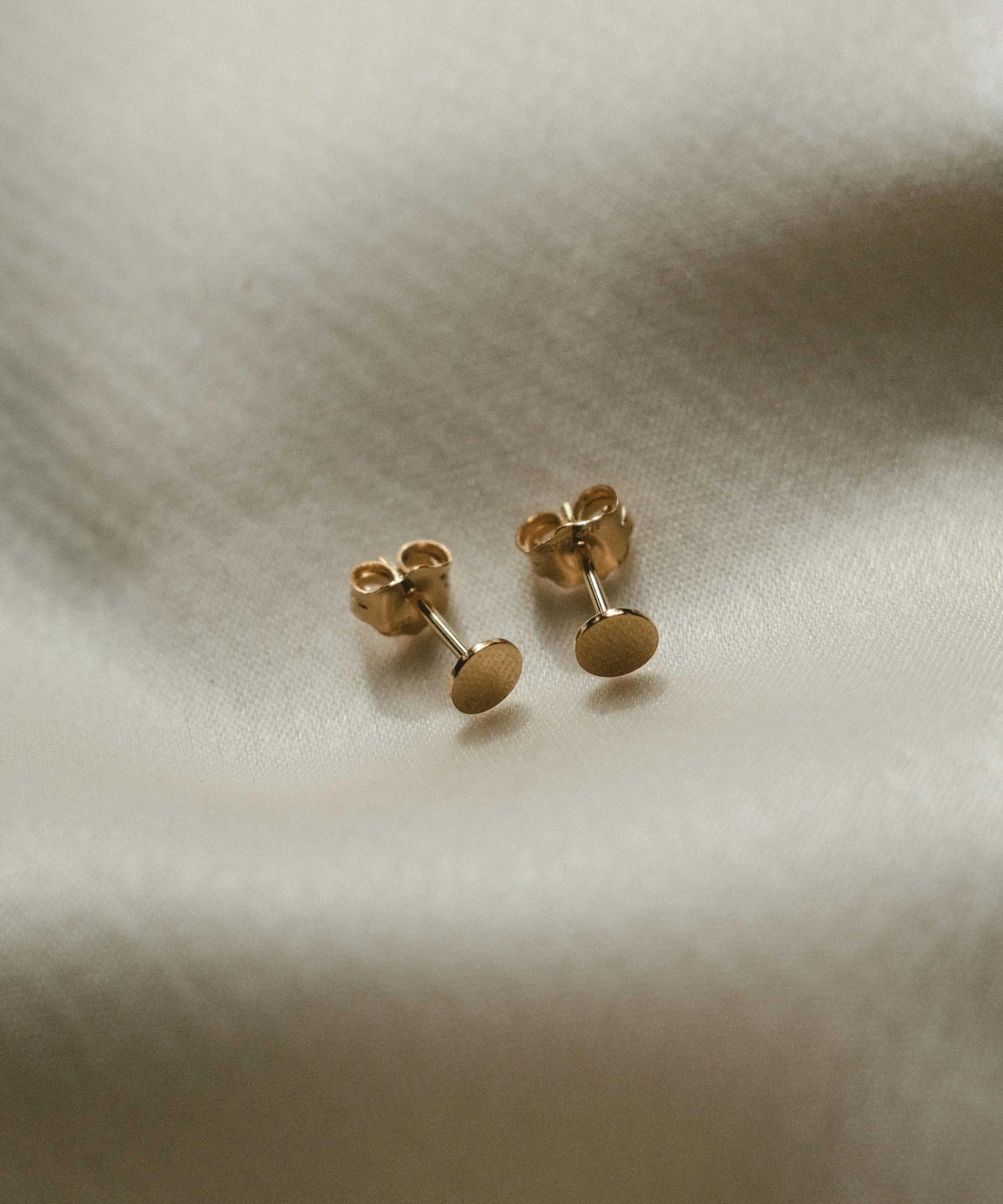 Round Disc Studs displayed on soft fabric for IGGI Jewellery product detail