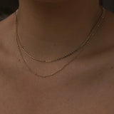Close-up of Satellite Ball Chain Necklace layered with flat ball chain on chest