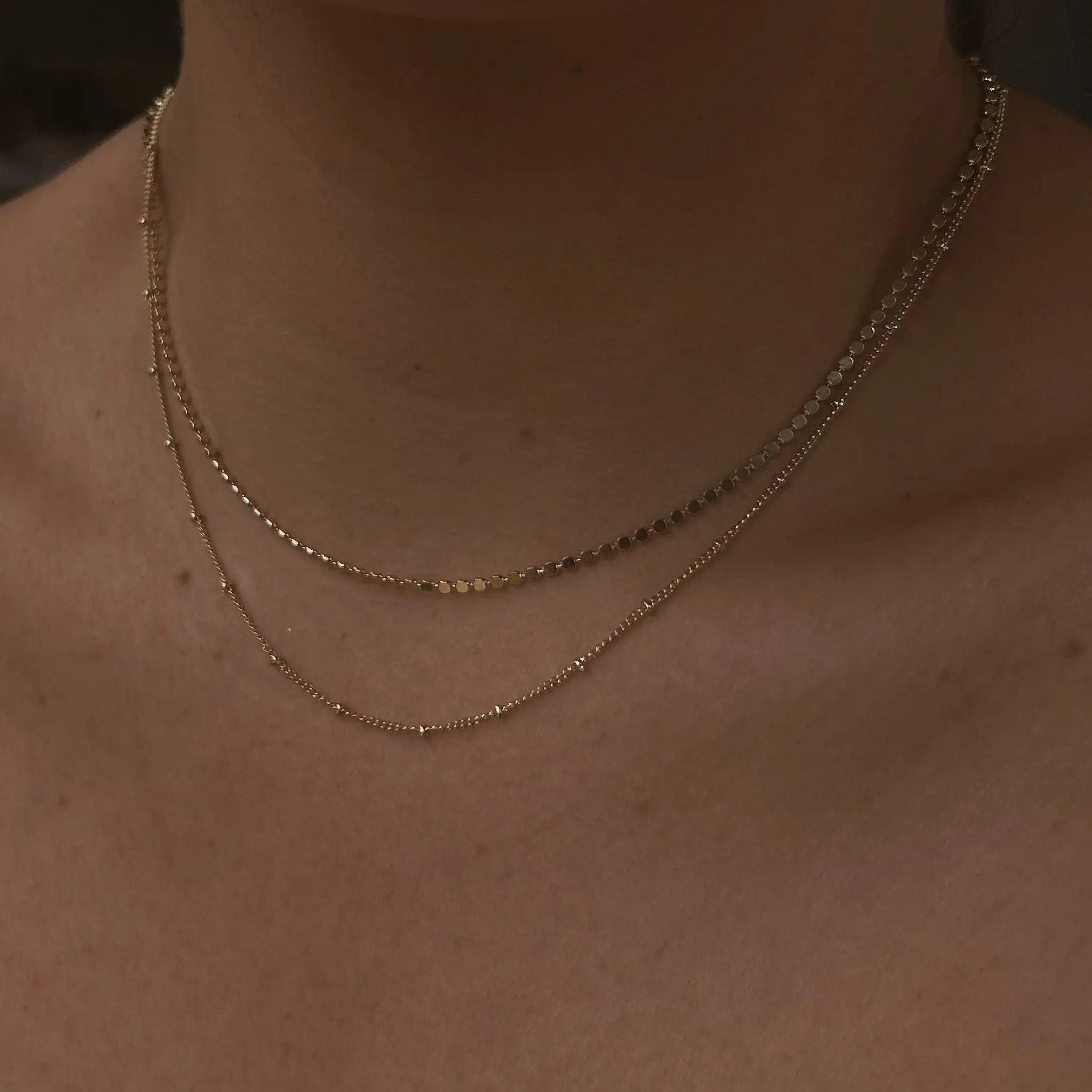 Close-up of Satellite Ball Chain Necklace layered with flat ball chain on chest