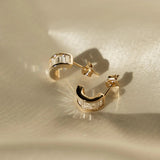 Sonia Studs gold-filled hoop earrings with baguette CZ stones displayed on satin fabric