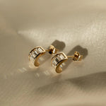 Sonia Studs 18k gold-filled hoop earrings with baguette-cut CZ stones on a neutral background