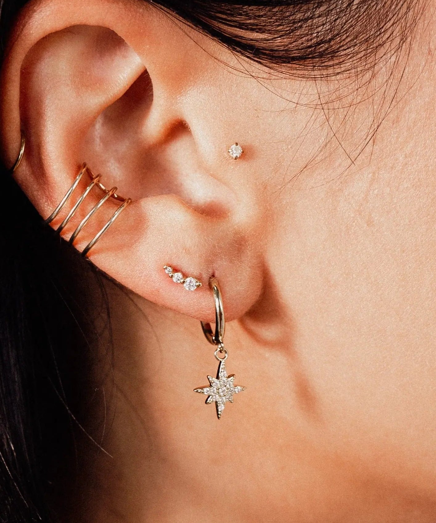 Close-up of IGGI Star Drop Earrings in 18k gold-filled with cubic zirconia charm styled on ear