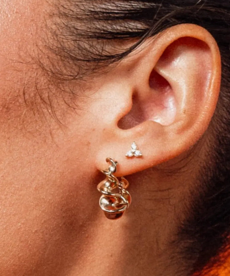 Model wearing Zara Twisted Hoops by IGGI Jewellery – 18k gold-filled twisted design hoop earrings.