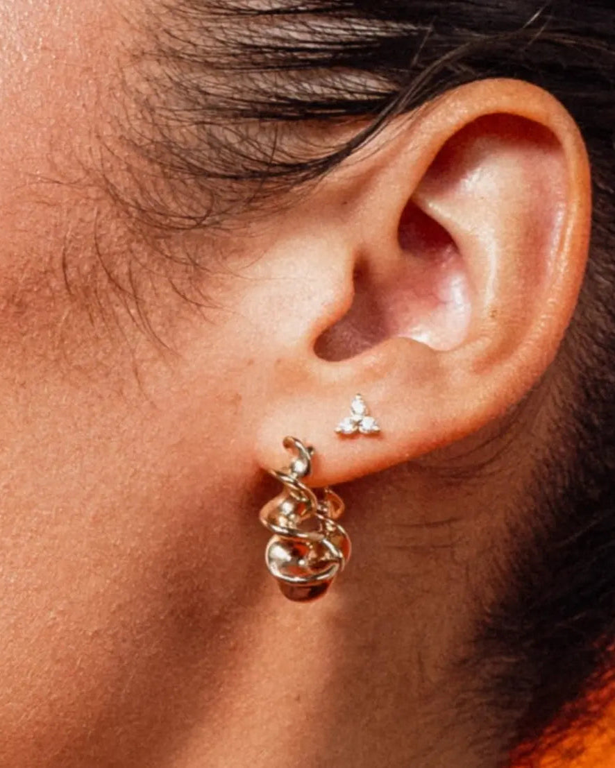 Model wearing Zara Twisted Hoops by IGGI Jewellery – 18k gold-filled twisted design hoop earrings.