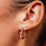 Model wearing Zara Twisted Hoops by IGGI Jewellery – 18k gold-filled twisted design hoop earrings.