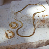 Close-up of model wearing 4mm gold-filled herringbone chain necklace – delicate and radiant